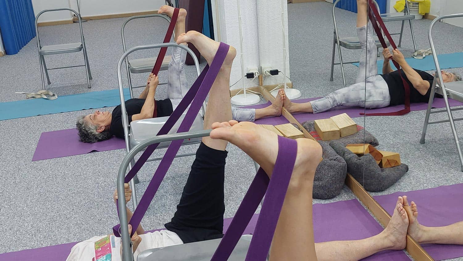 Clase de yoga con cinta elástica y silla